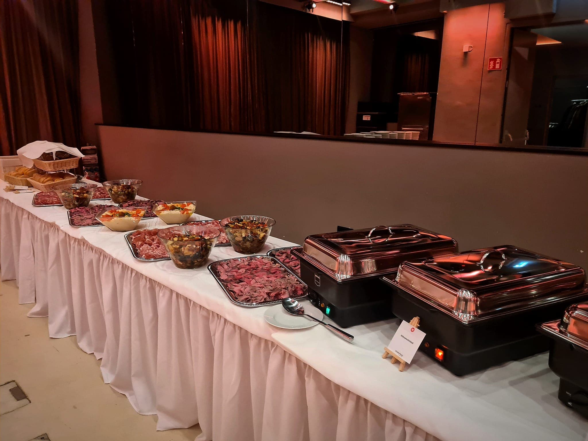 Festlich beleuchtete Buffet-Linie mit Chafing Dishes von charlyfresh bei einer Abendveranstaltung in Wien