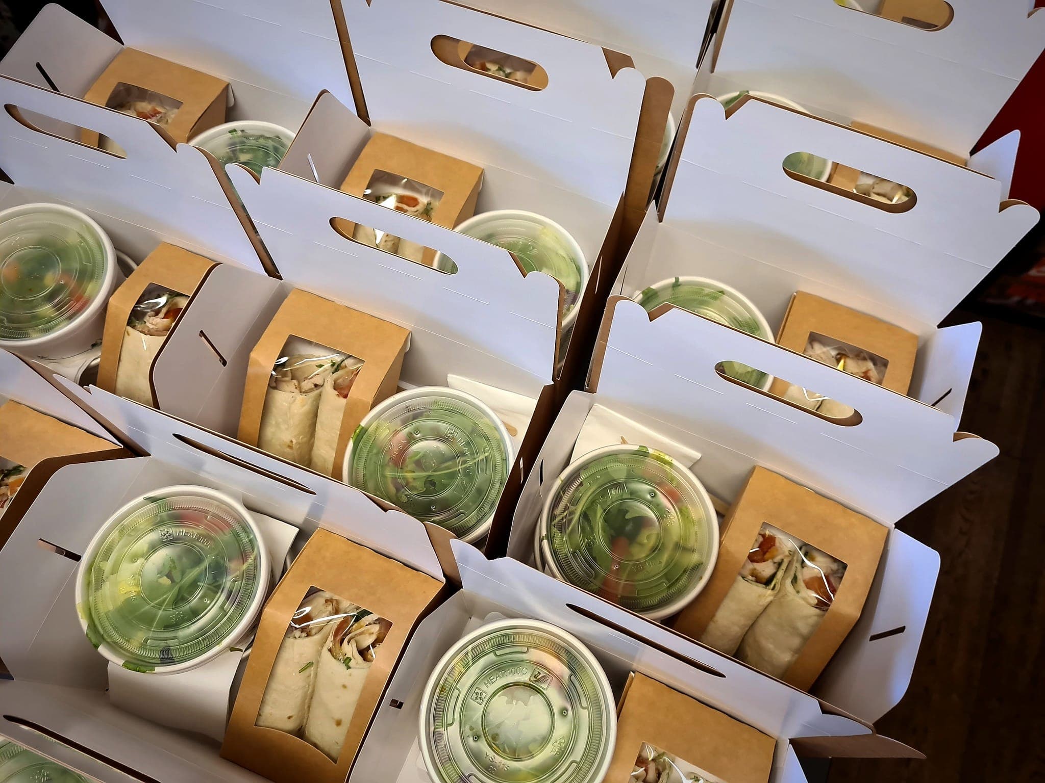 Geöffnete charlyfresh Lunchboxen mit Wrap und Salat-Bowl — Express-Catering fürs Büro in Wien