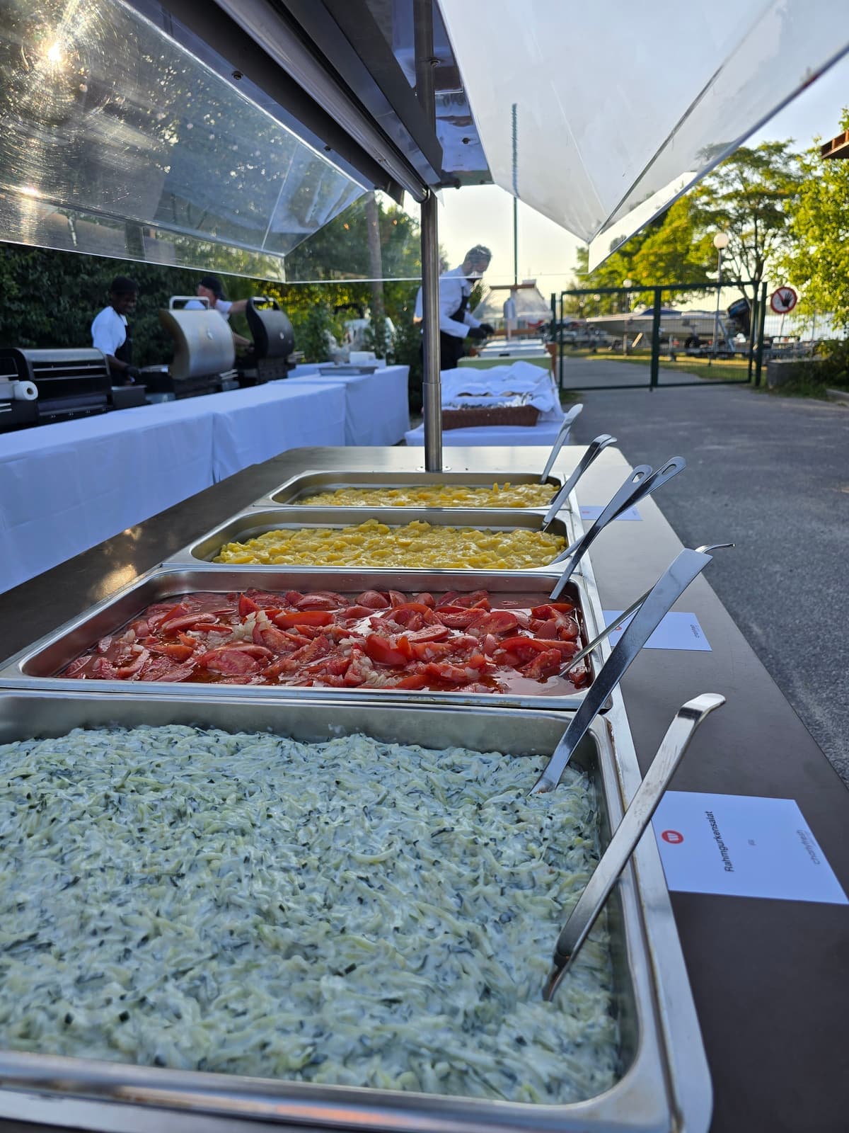 Outdoor-Buffetlinie mit Salaten und warmen Speisen bei einem Sommerfest