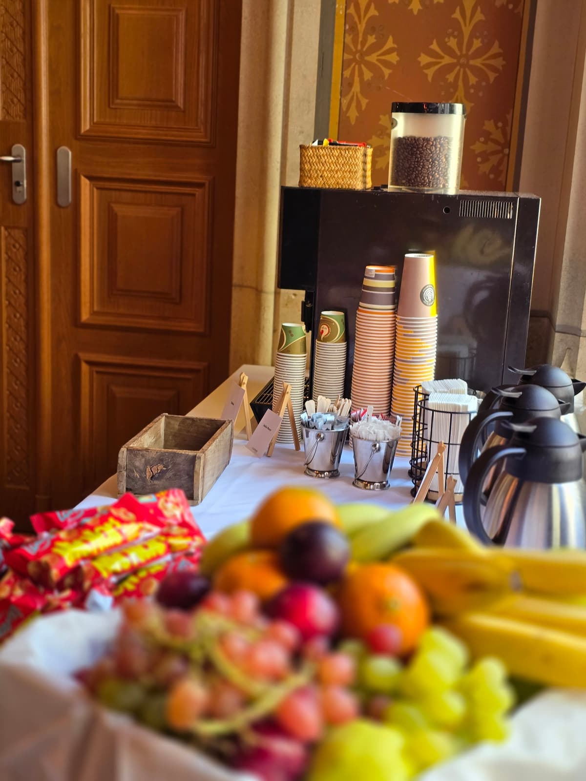 Kaffeepause mit Thermoskannen und frischem Obst